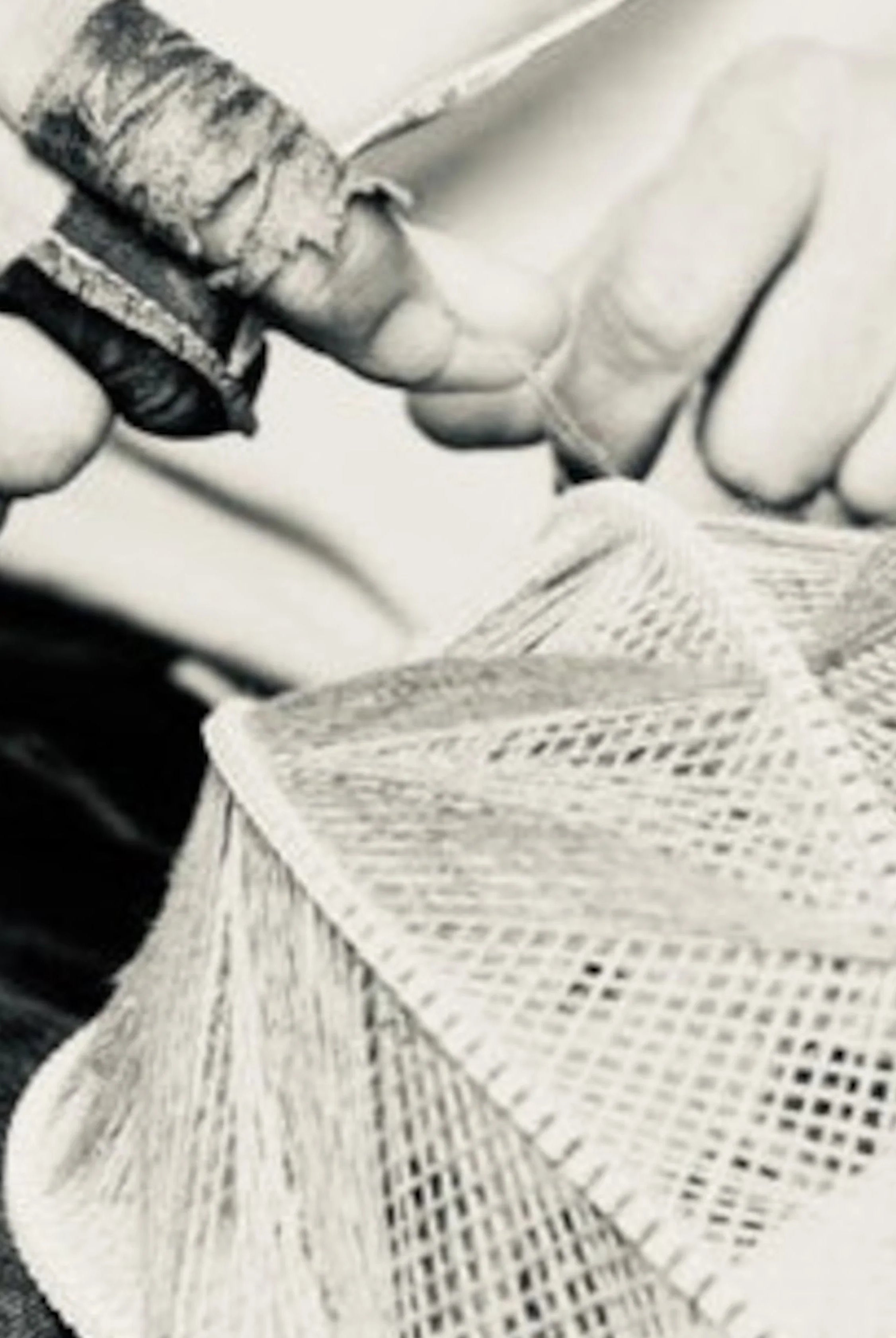 Nahaufnahme von zwei Händen, die einen Lampenschirm weben