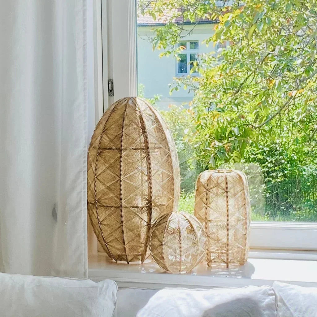 drei handgemachte Stehleuchte aus Birkenholz und Leinengarn der Kollektion Alentejo stehen auf einer Fensterbank