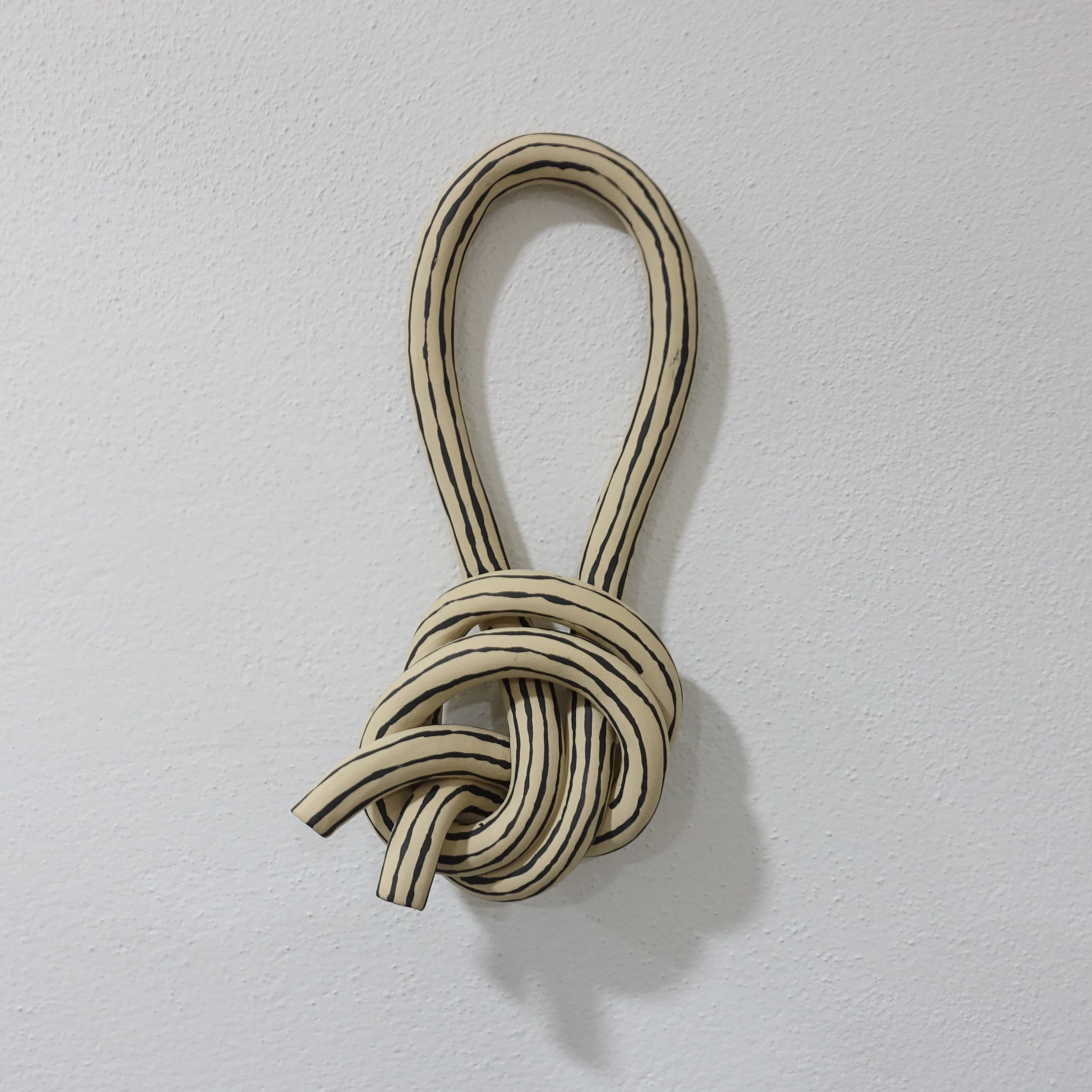 Wandskulptur STRIPED KNOT 1 Vorderansicht, handgefertigtes Keramikobjekt von Alice Del Ferraro