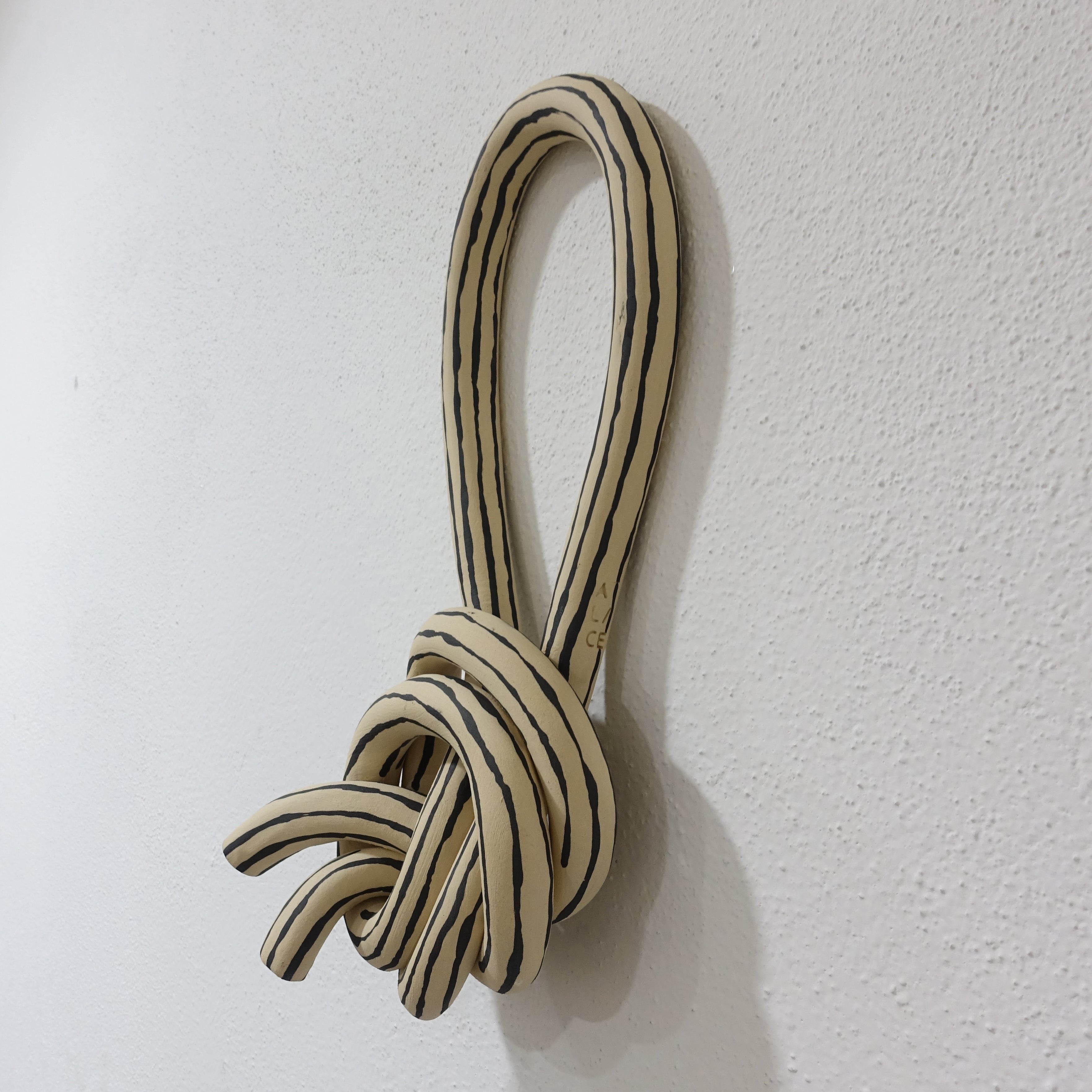 Wandskulptur STRIPED KNOT 1 Vorderansicht, handgefertigtes Keramikobjekt von Alice Del Ferraro