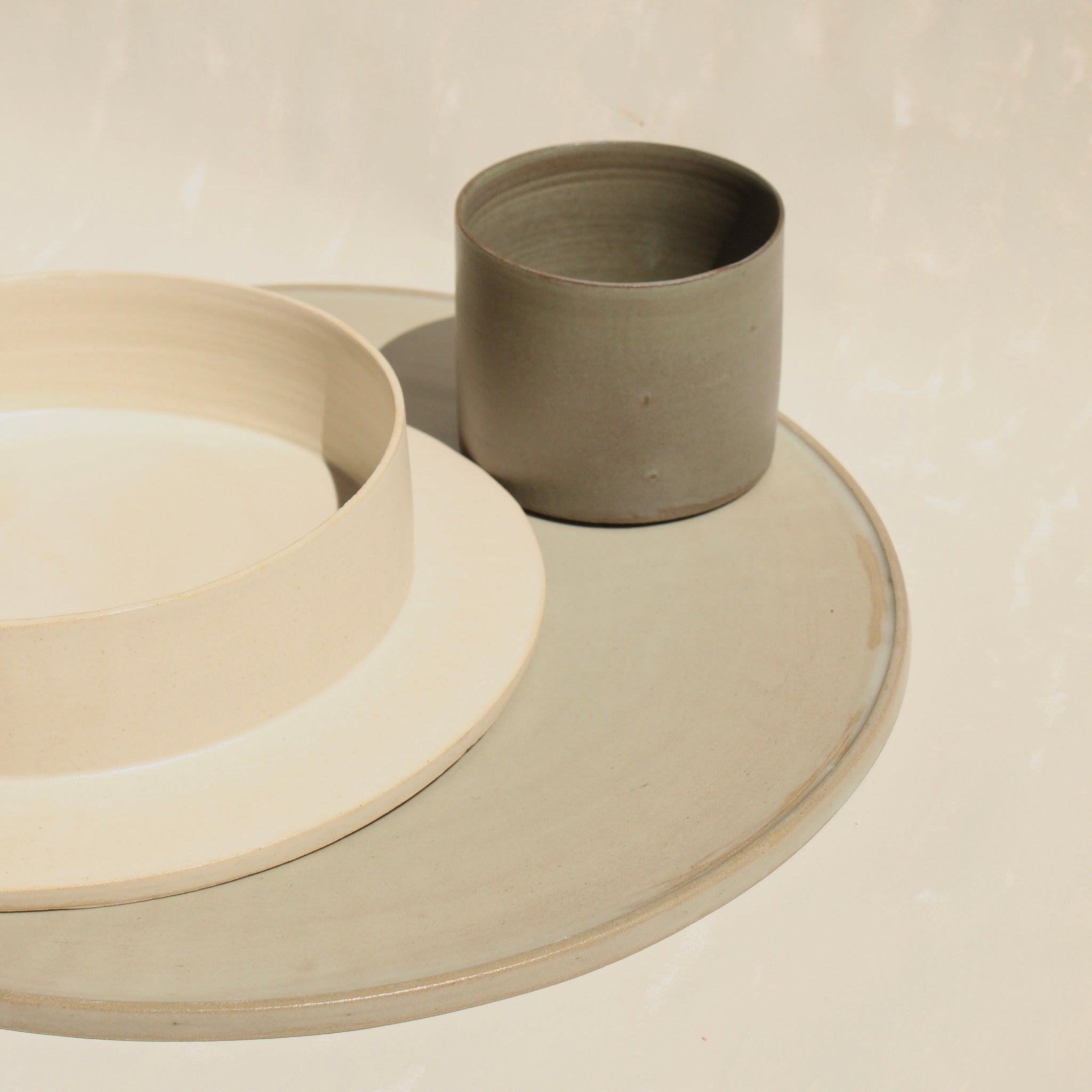 Ein modulares Set der handgefertigten Steingut-Kollektion ROSA MORADA der Genueser Künstlerin Martina Geroni, bestehende aus einem grossemn Pizzateller/Platzset, einem Suppenteller/einer Schale und einem Becher.