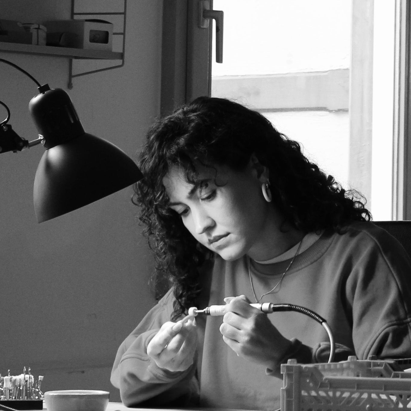 Schmuckdesignerin Alexandra Schütz arbeitet mit einem Dremel an der Politur eines Polymerton-Ohrrings in ihrem Atelier in Lörrach.