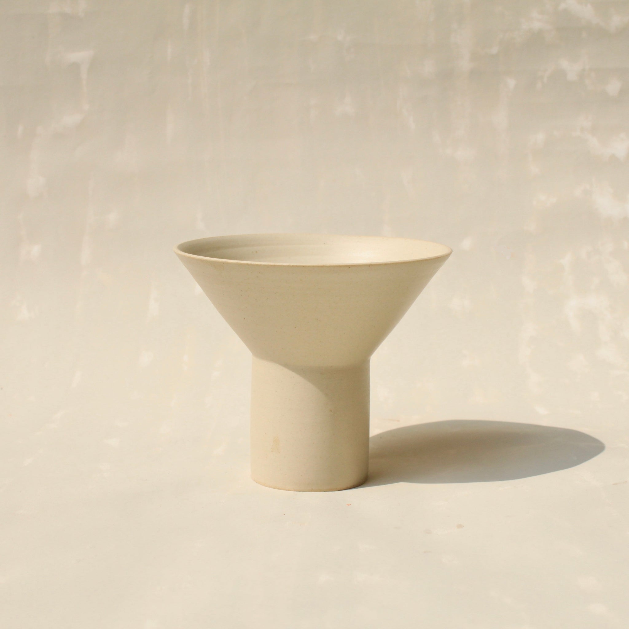 Der Becher TABLINO aus Keramik kann sowohl als kegelförmges Schälchen mit zylindrischem Sockel für Tee genutzt werden, oder gewendet als Espressobecher mit kegelförmigen Fuss.