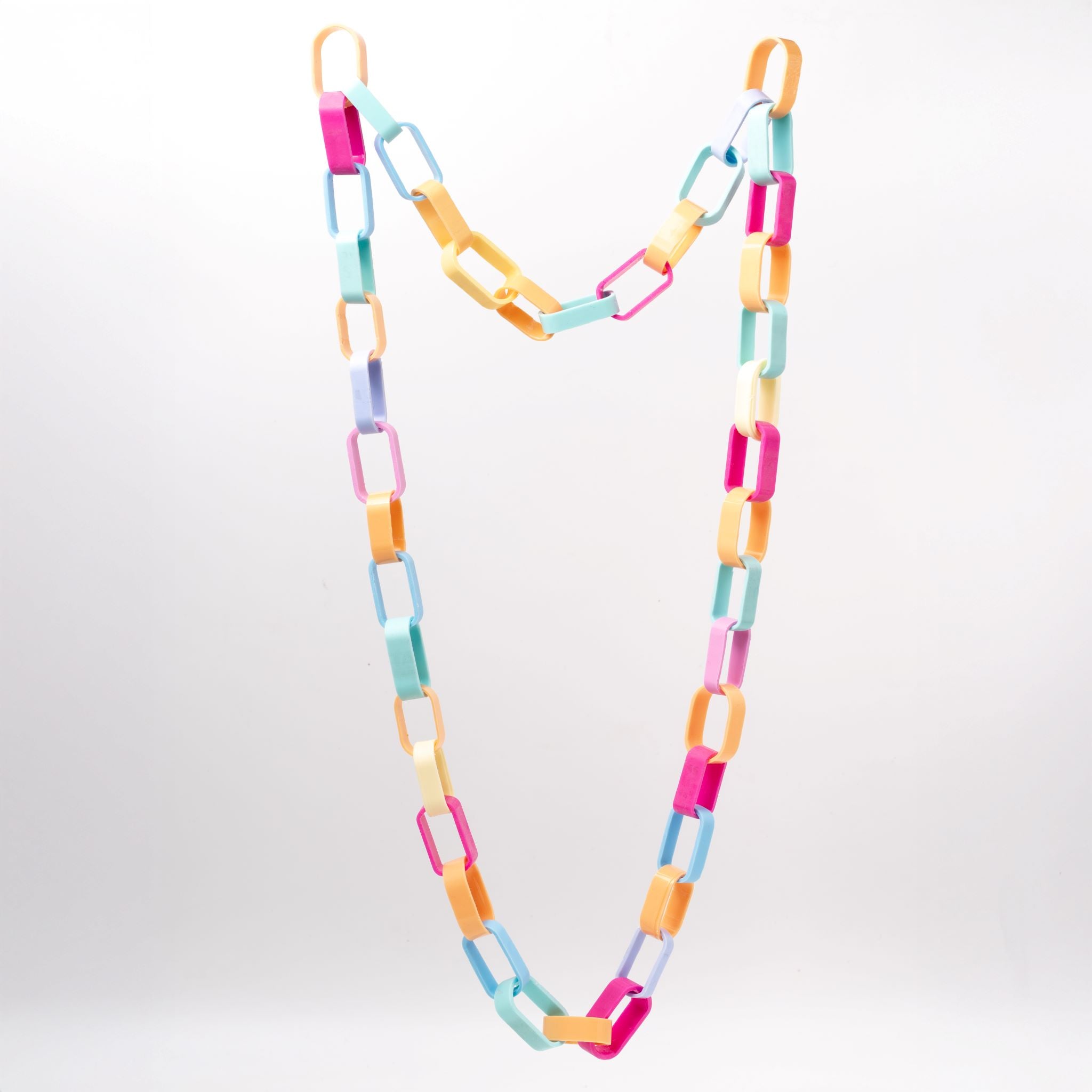 Nahaufnahme einer Gliederkette der Schmuckdesignerin Carla Movia, deren große Glieder in pastelligen, aber kräftigen Farben aus recyclten Hülsen von Textmarkern bestehen.