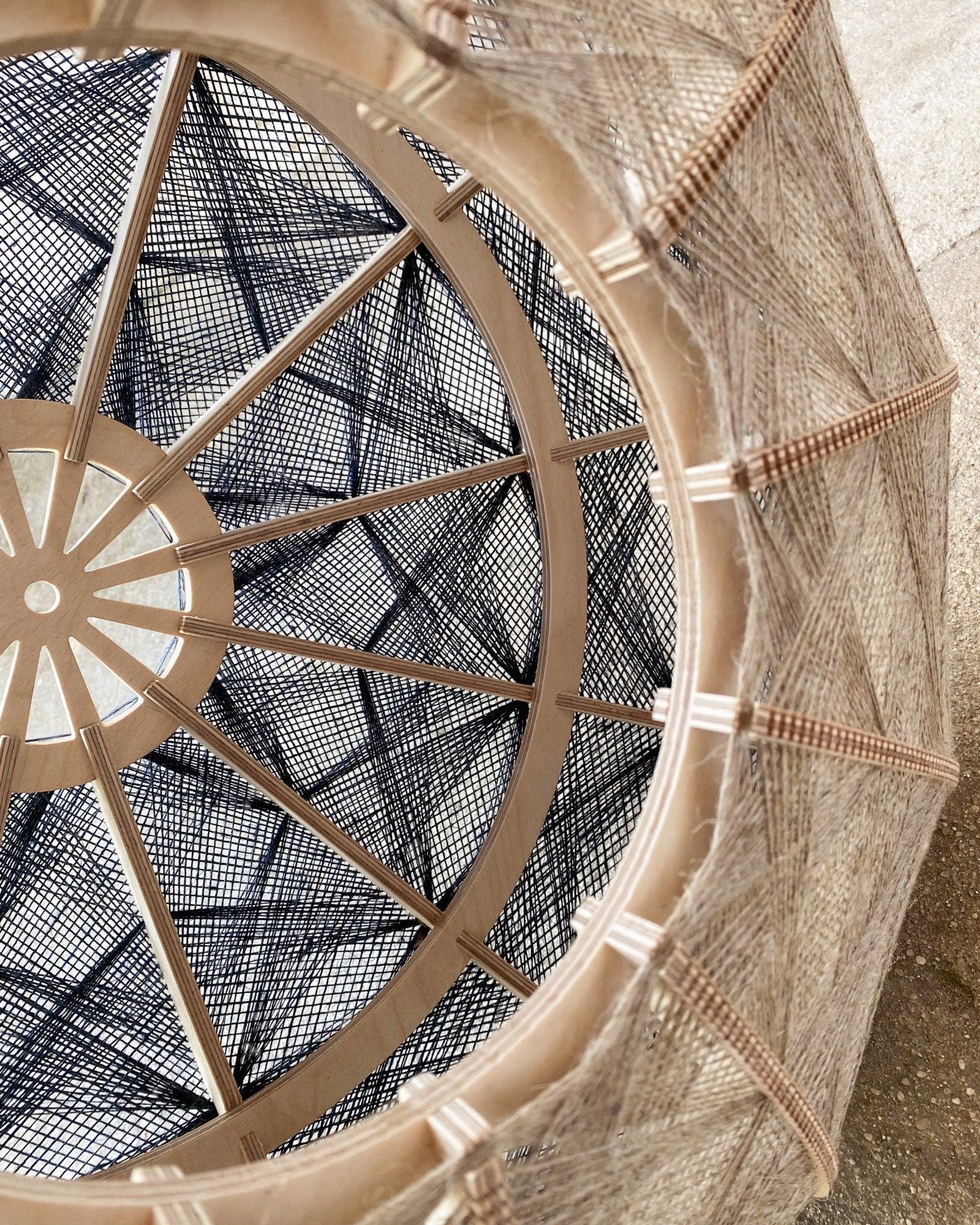 Detailaufnahme des Inneren eines Lampenschirms aus Birkenholz und gewebtem Leinengarn in Beige und Anthrazit