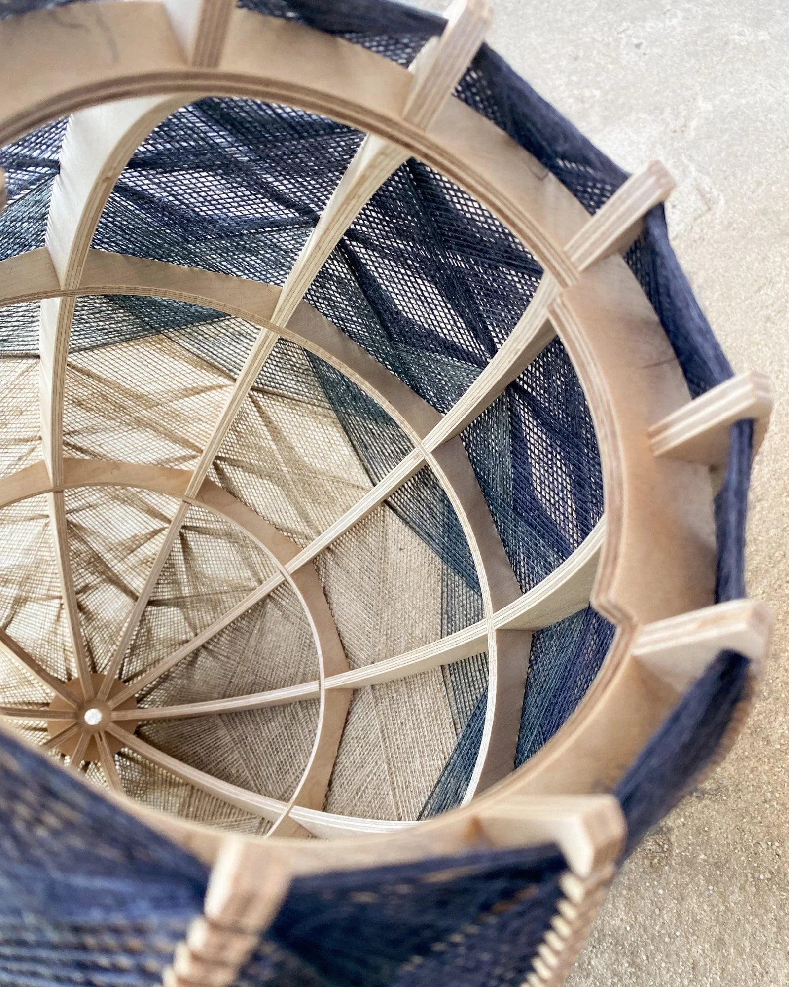 Detailaufnahme des Birkenholzrahmens und des zweifarbigen Webmuster der Designlampe Helli von Innen