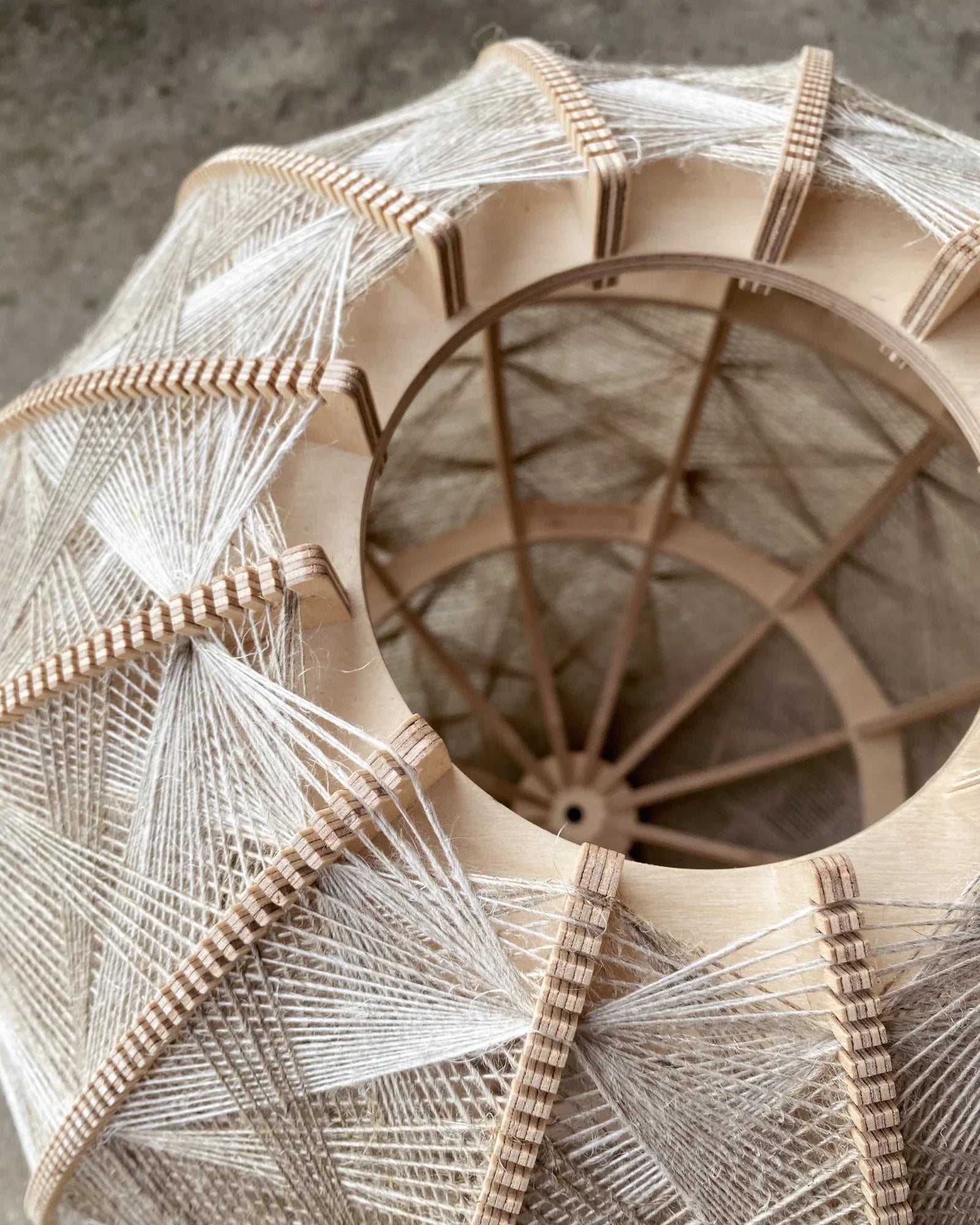 Detailaufnahme des Birkenholzrahmens und des zweifarbigen Webmuster der Designlampe Helli von Innen