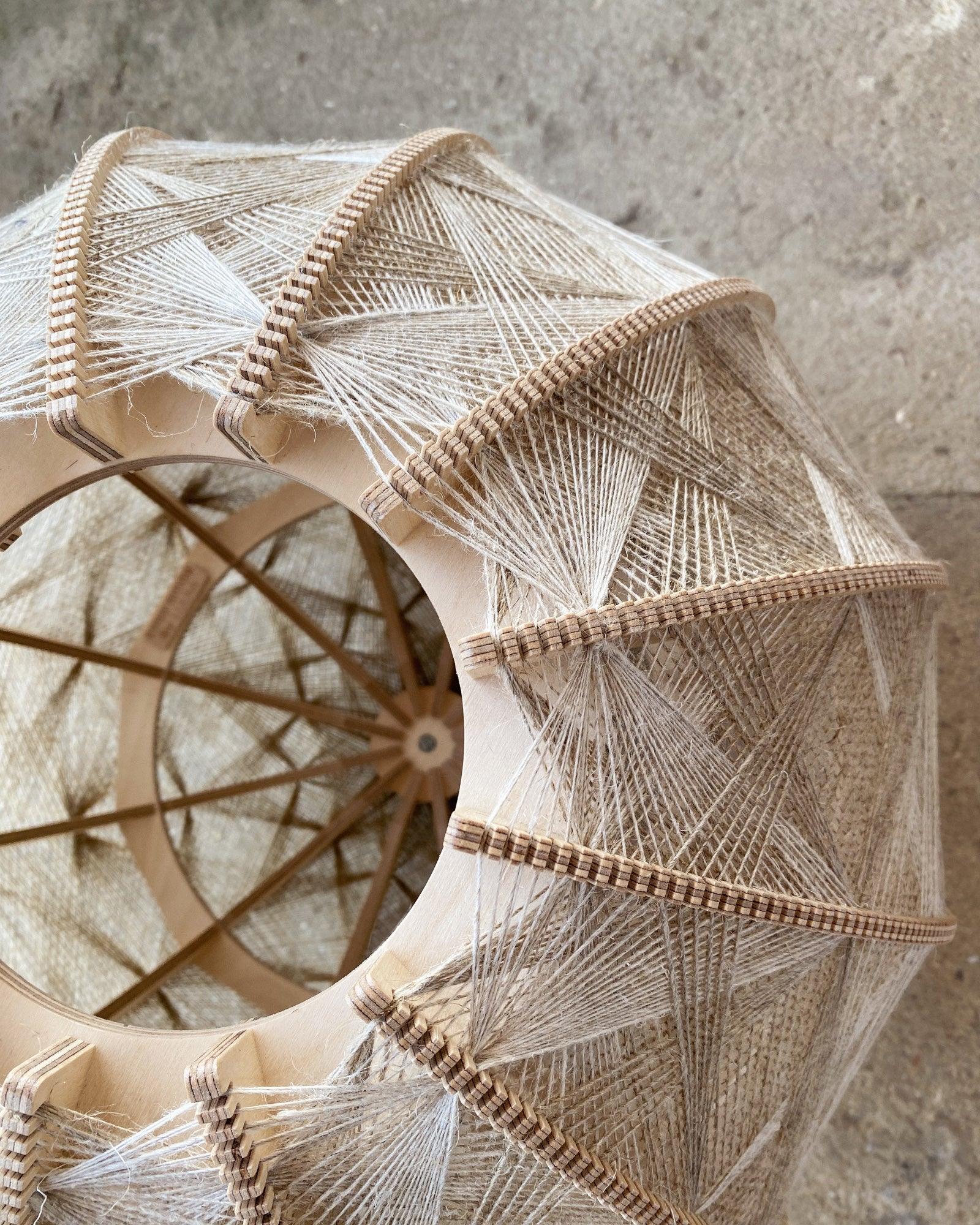 Detailaufnahme ins Innere eines Lampenschirm aus Birkenholz und gewebtem Leinengarn