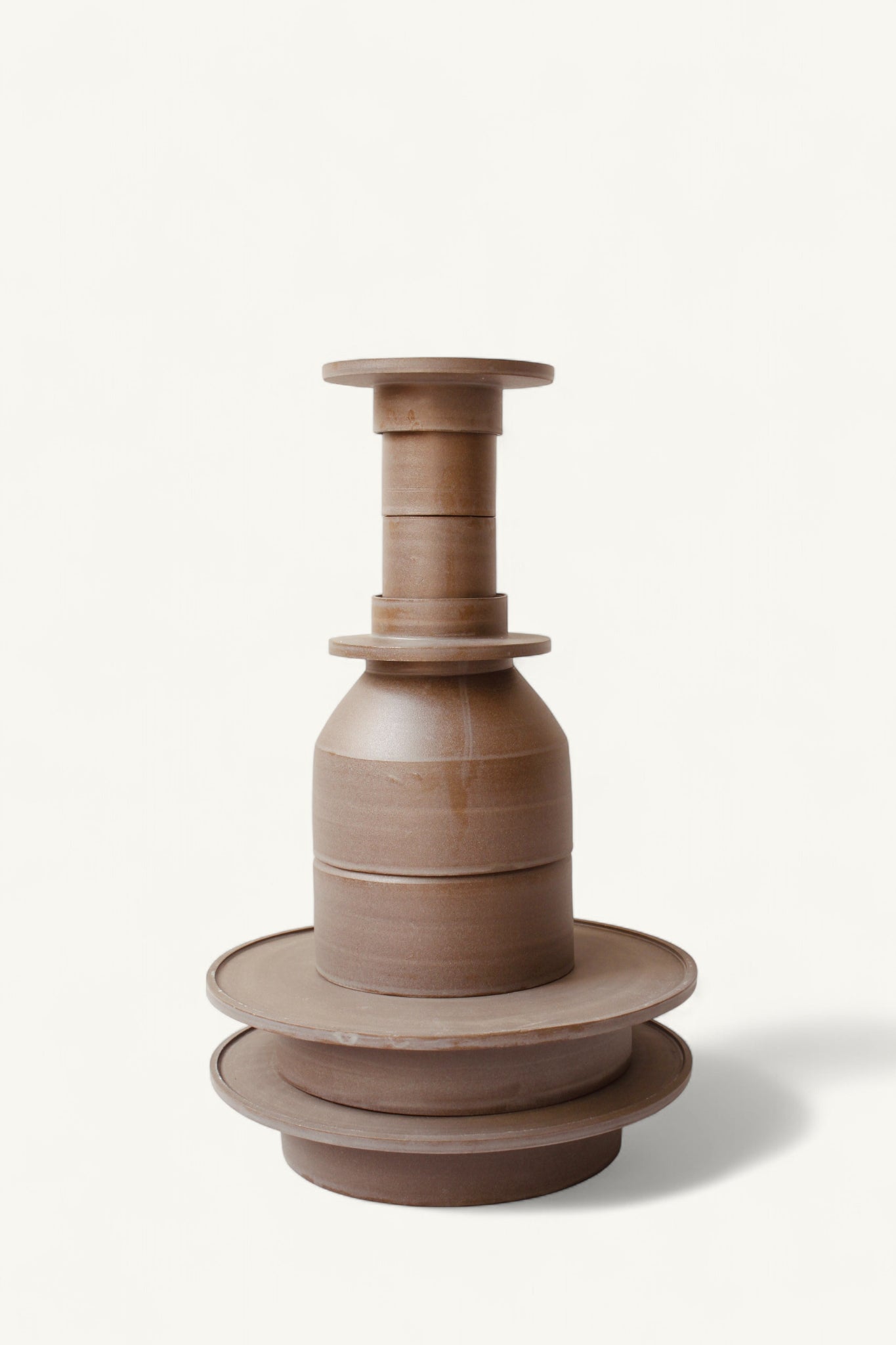 Gestapelte Geschirrskulptur Domenico & Filumena aus der Kollektion ROSA MORADA von Martina Geroni in der Tonfarbe Buccia di Zenzero, bestehend aus zwei Espressobechern mit Schälchen, 2 Schalen und 2 Tellern aus handgefertigtem Steingut.