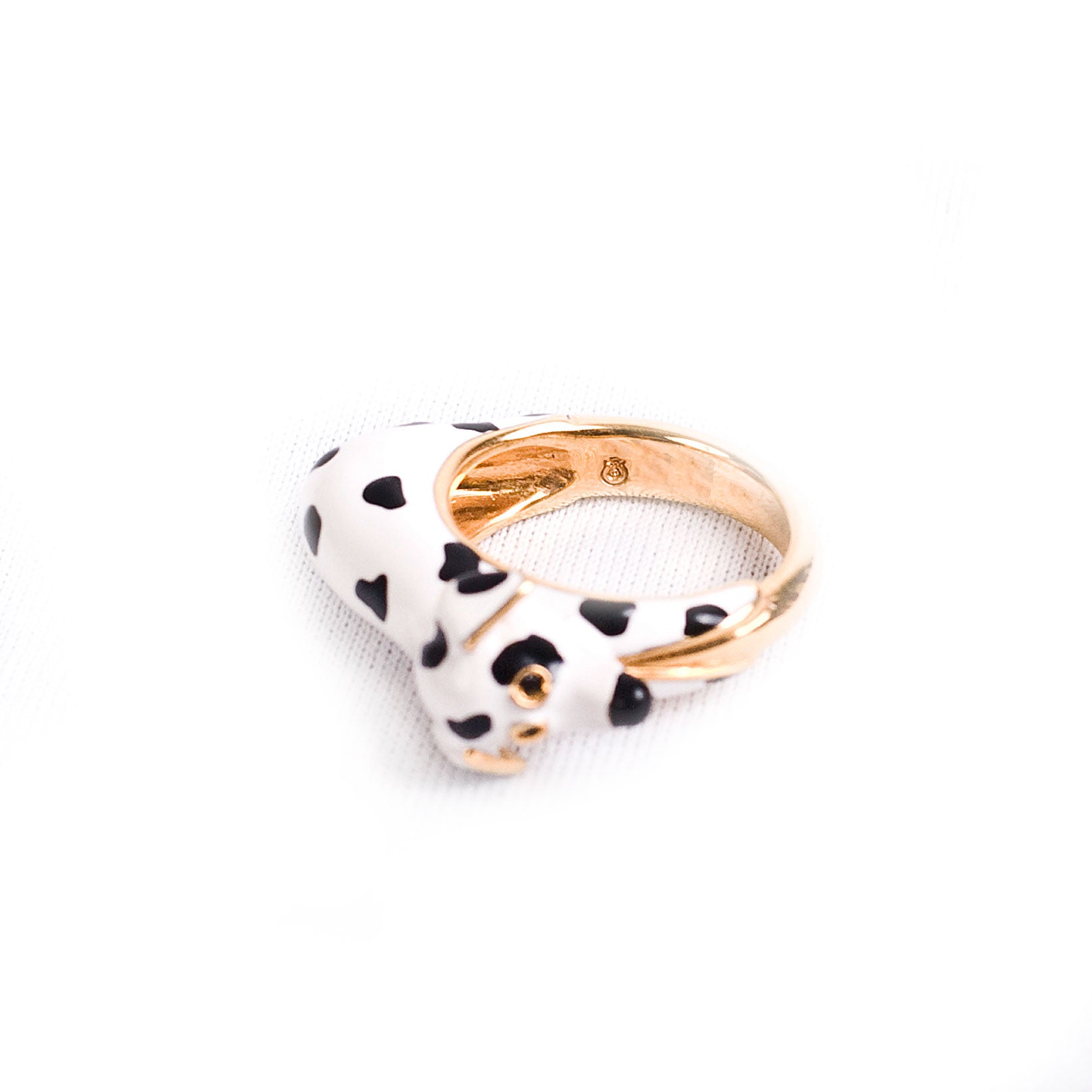 Ein Fingerring der italienischen Schmuckdesignerin Chiara Bello in Form eines Dalmatiners mit schwarzen Steinchen als Augen und goldenen Konturen.