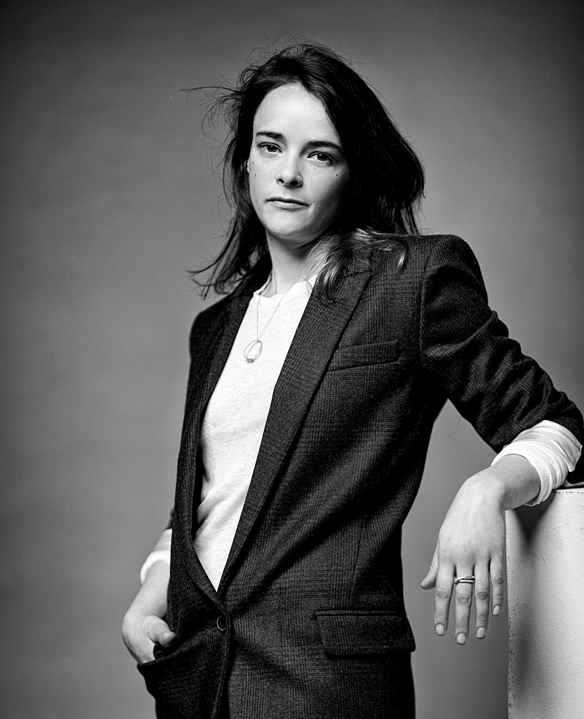 Schwarz-weiss Porträt der Schmuckdesignerin und Gold- und Silberschmiedin Annie Sibert in einem karierten Jacket.
