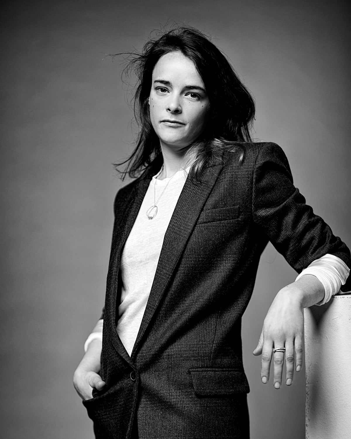 Schwarz-weiss Porträt der Schmuckdesignerin und Gold- und Silberschmiedin Annie Sibert in einem karierten Jacket.