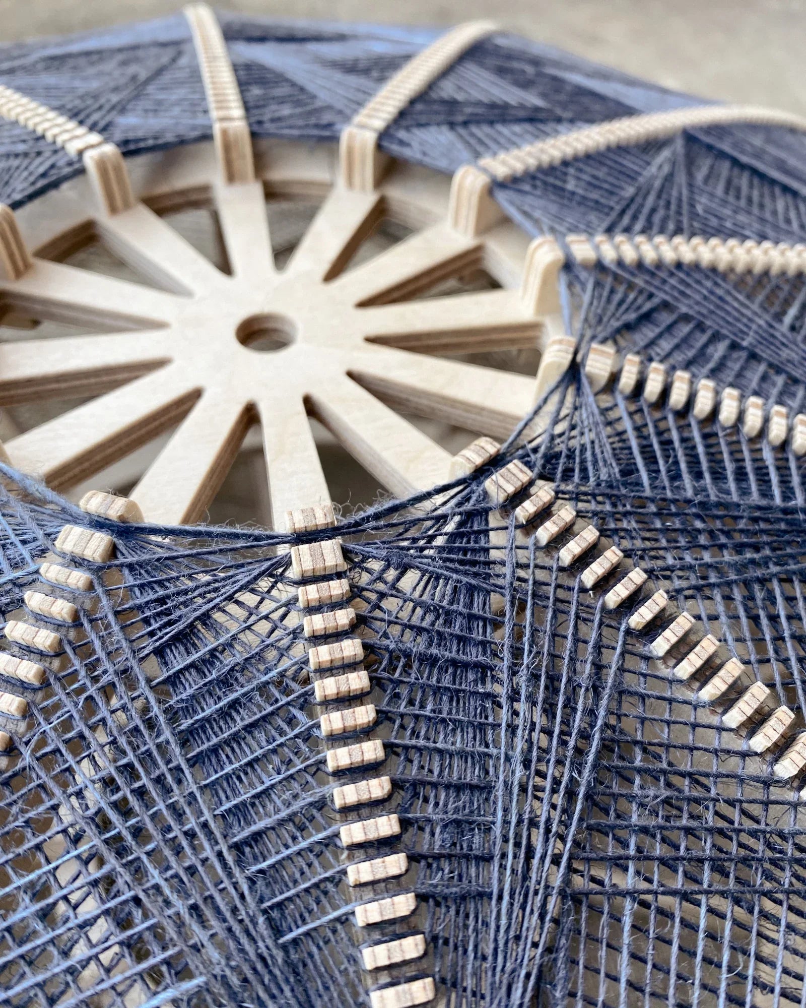 Detailaufnahme des Rahmens und Webmusters eines Lampenschirms aus Birkenholz und Leinengarn in Beige und Anthrazit