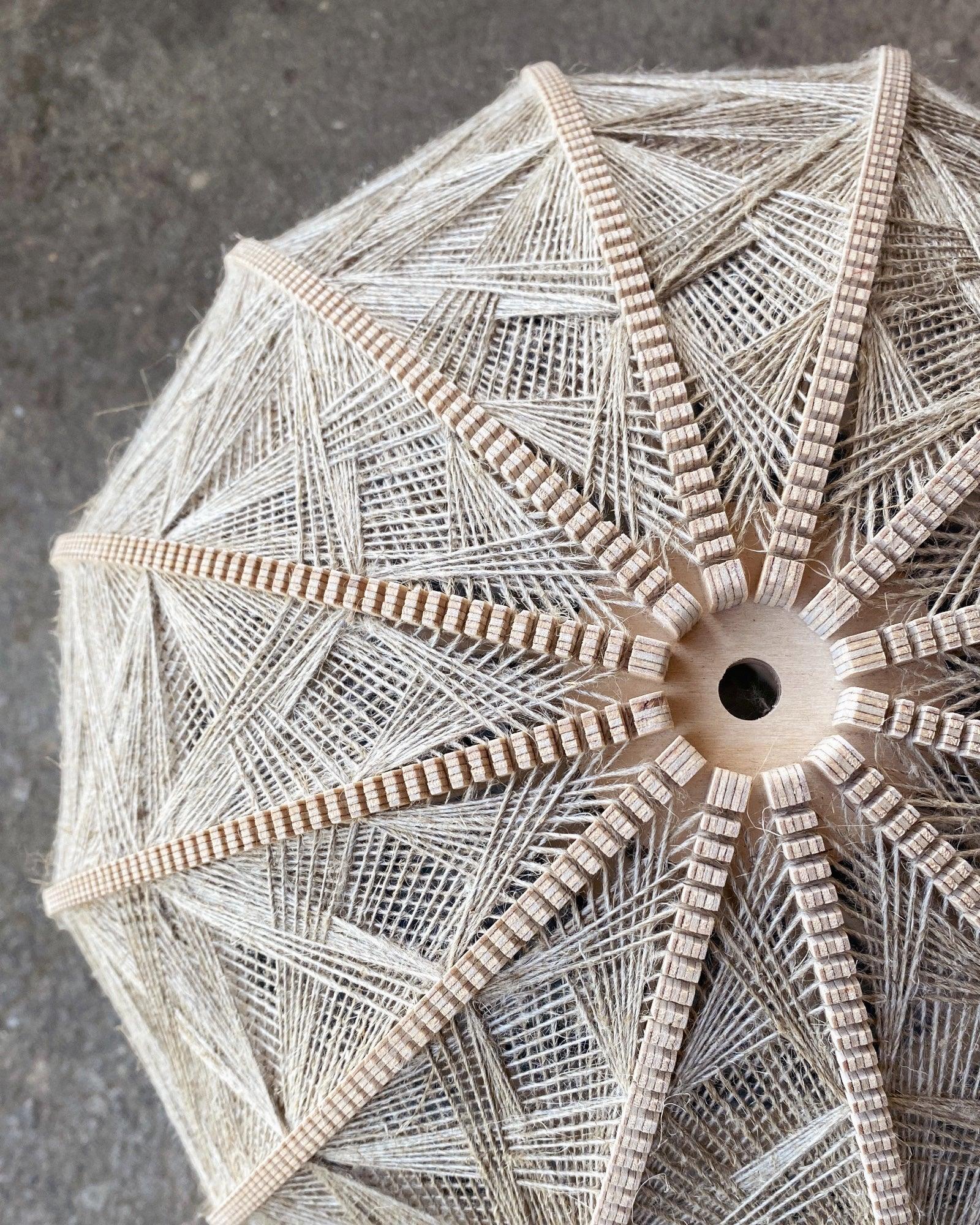 Detailaufnahme des Rahmens und Webmusters eines Lampenschirm aus Birkenholz und Leinengarn in Beige