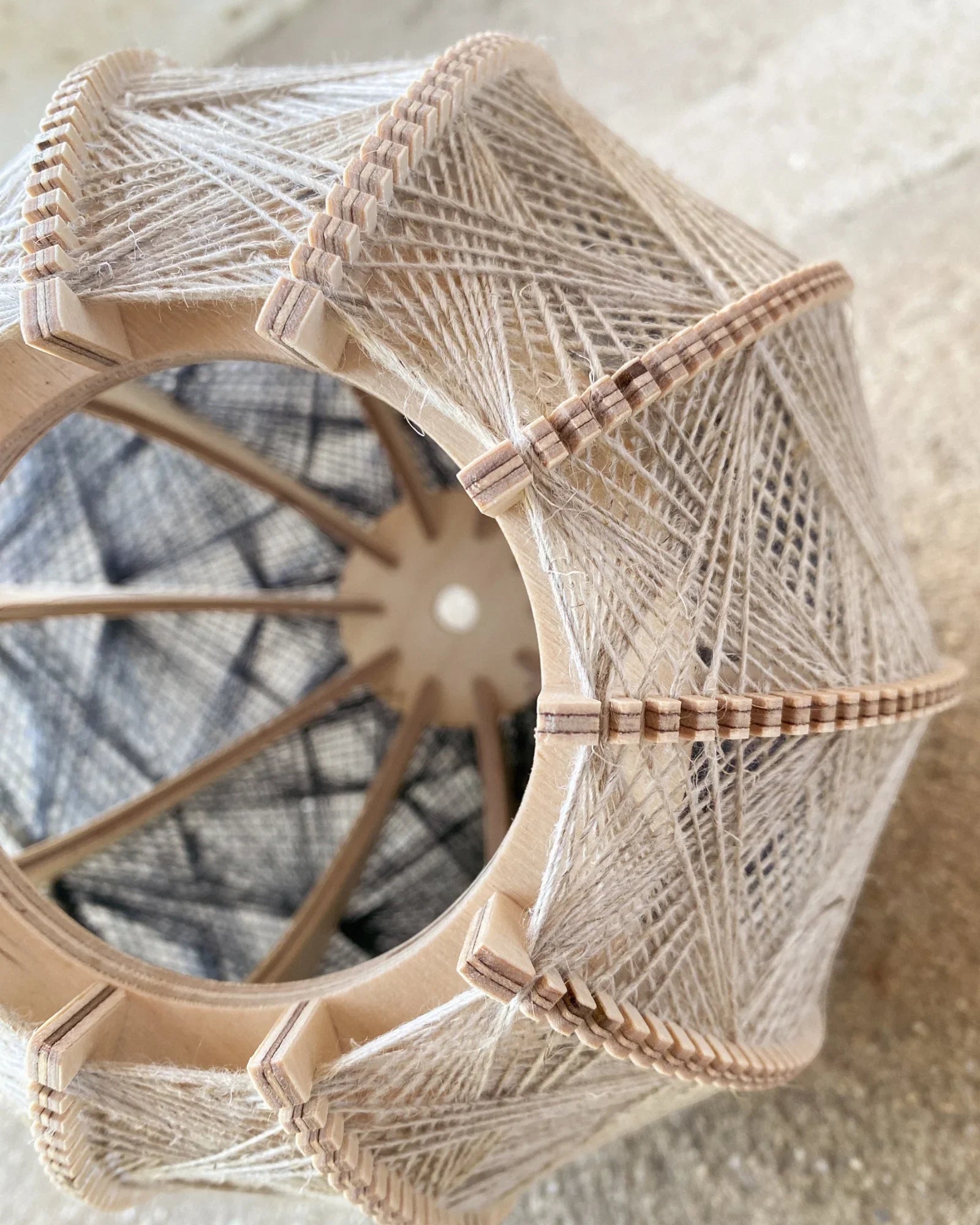 Detailaufnahme des Rahmens und Webmusters eines Lampenschirm aus Birkenholz und Leinengarn in Beige und Anthrazit