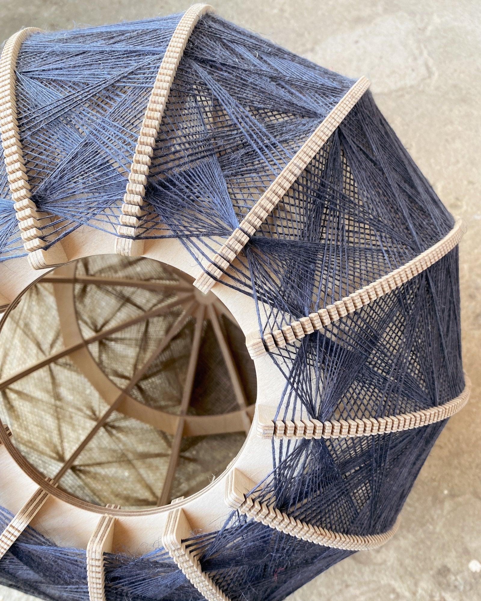 Detailaufnahme des Rahmens und Webmusters eines Lampenschirm aus Birkenholz und Leinengarn in Beige und Anthrazit