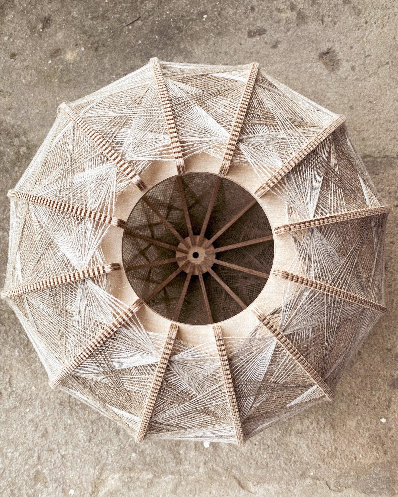 Detailaufnahme des Rahmens und Webmusters eines Lampenschirms aus Birkenholz und gewebtem Leinengarn