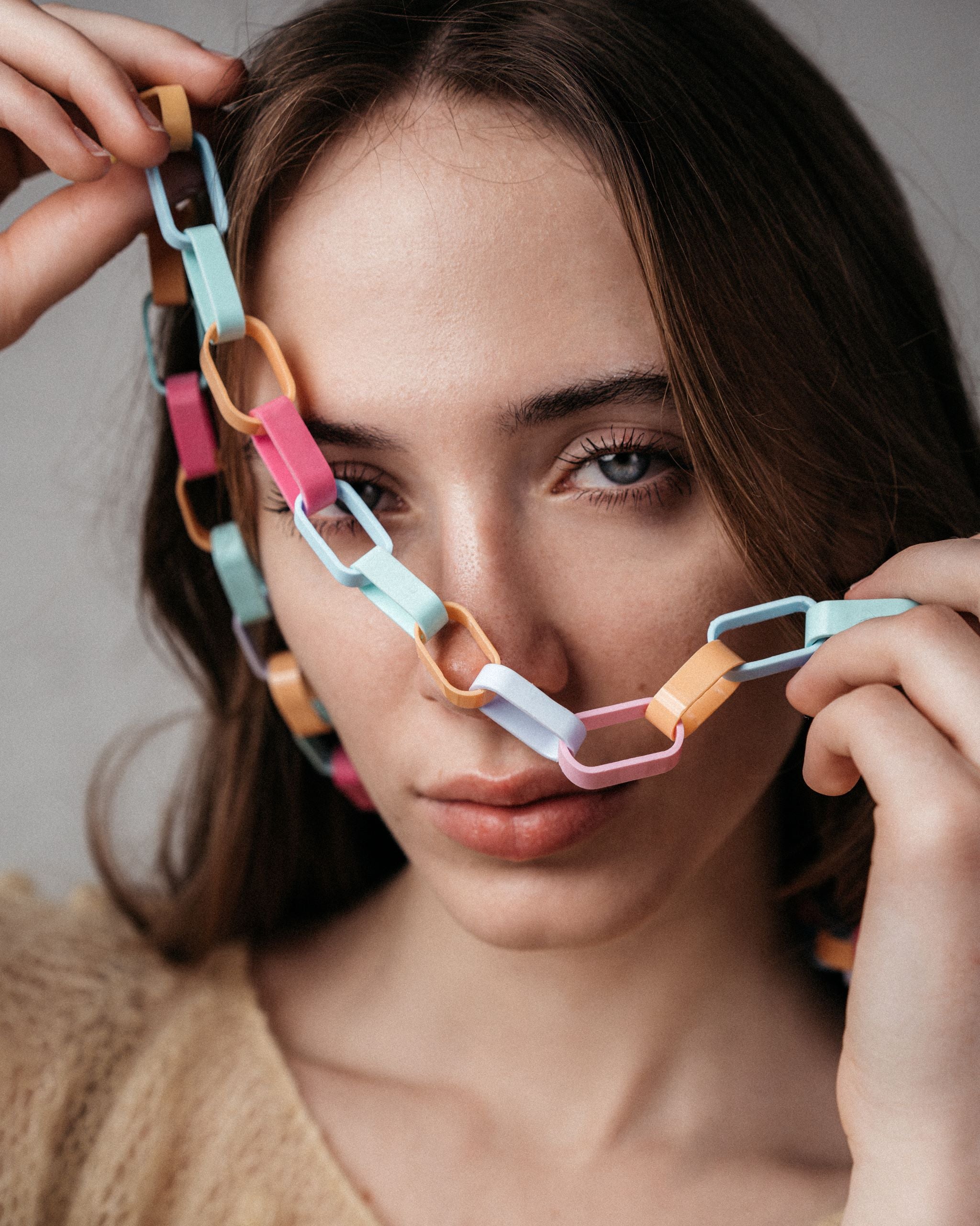 Ein Model trägt eine Gliederkette der Schmuckdesignerin Carla Movia, deren große Glieder in pastelligen, aber kräftigen Farben aus recyclten Hülsen von Textmarkern bestehen