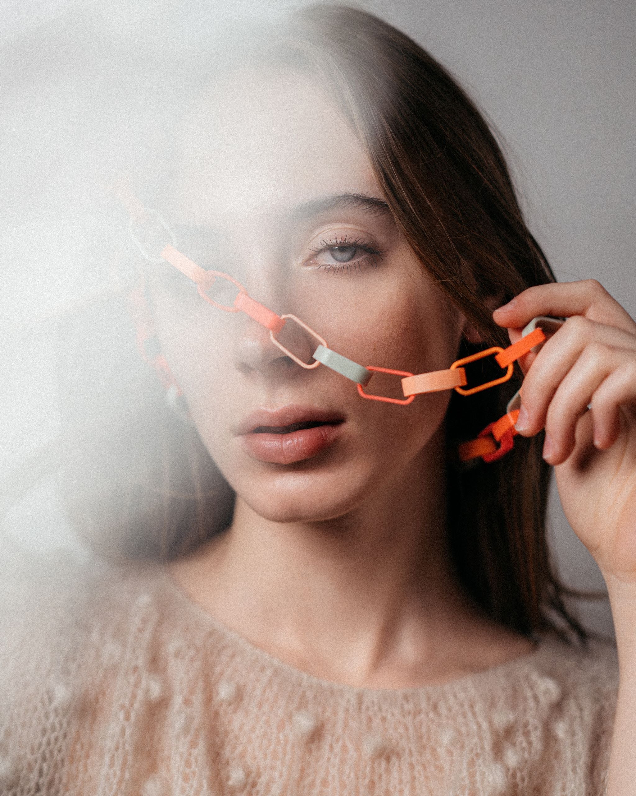 Ein Model trägt eine Gliederkette der Schmuckdesignerin Carla Movia, deren große Glieder in herbstlich leuchtenden Farben aus recyclten Hülsen von Textmarkern bestehen.