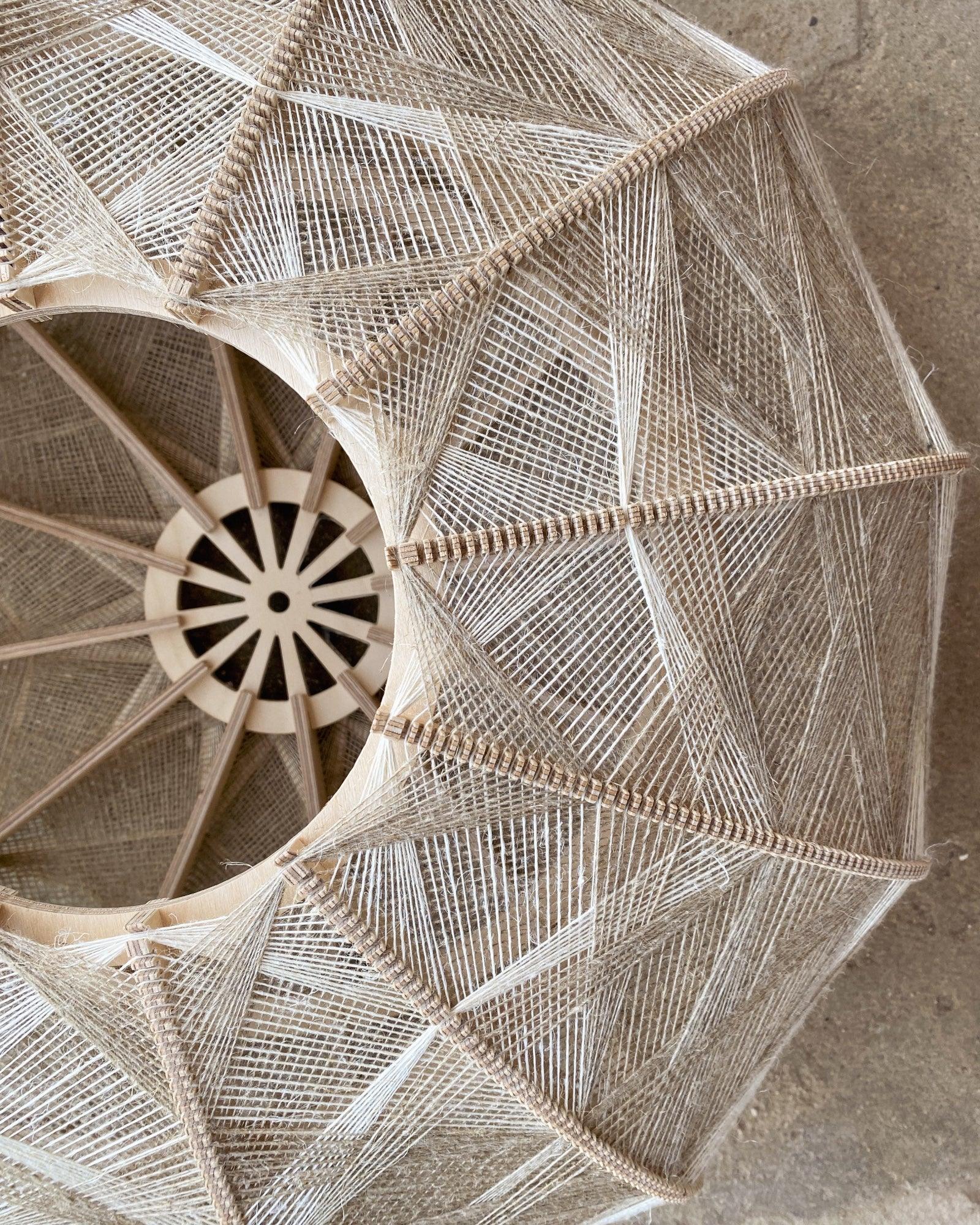 Detailaufnahme des Inneren eines Lampenschirms aus Birkenholz und gewebtem Leinengarn in Beige