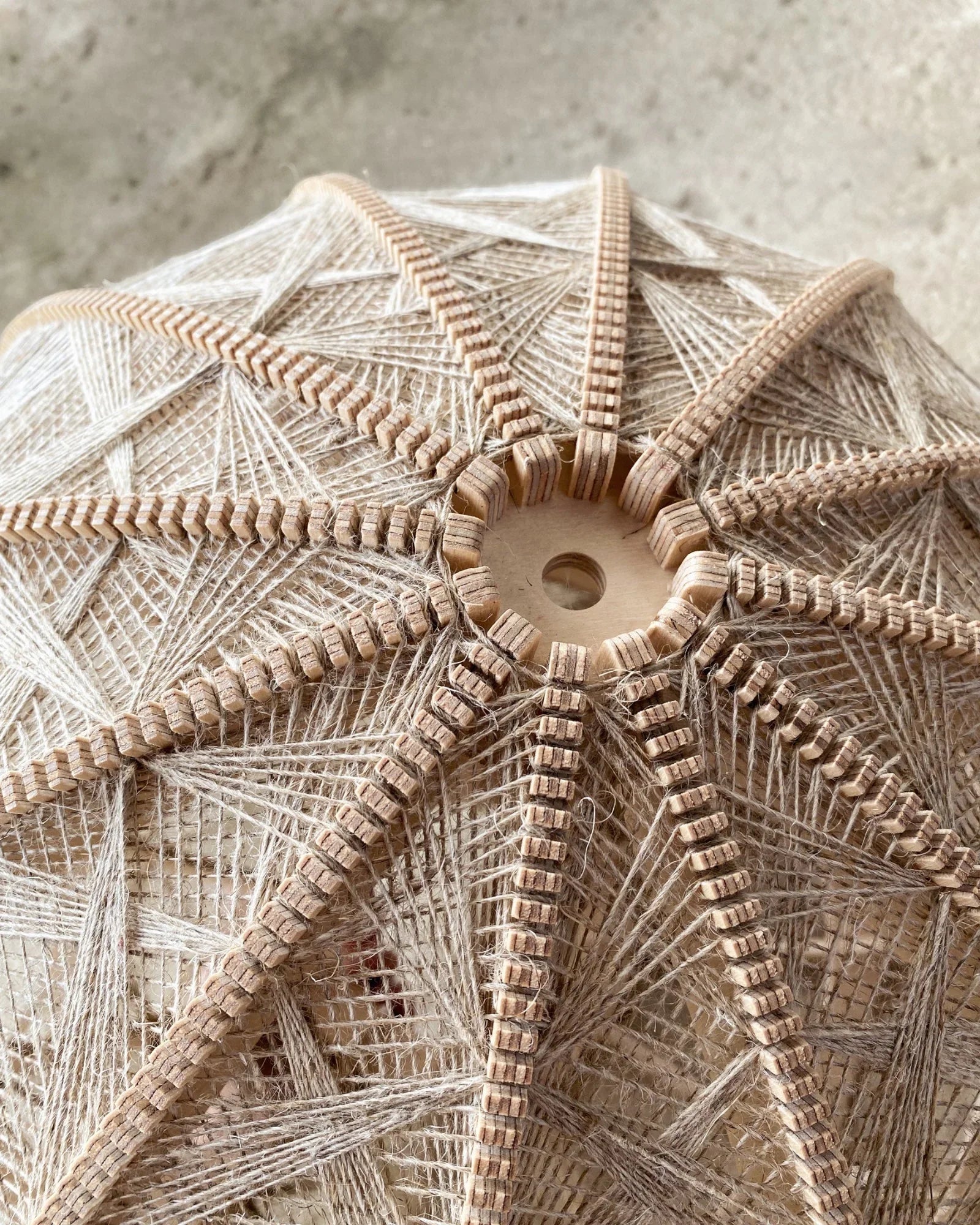 Detailaufnahme des Webmuster in Naturtönen auf hellem Birkenholzrahmen der Stehlampe Helli