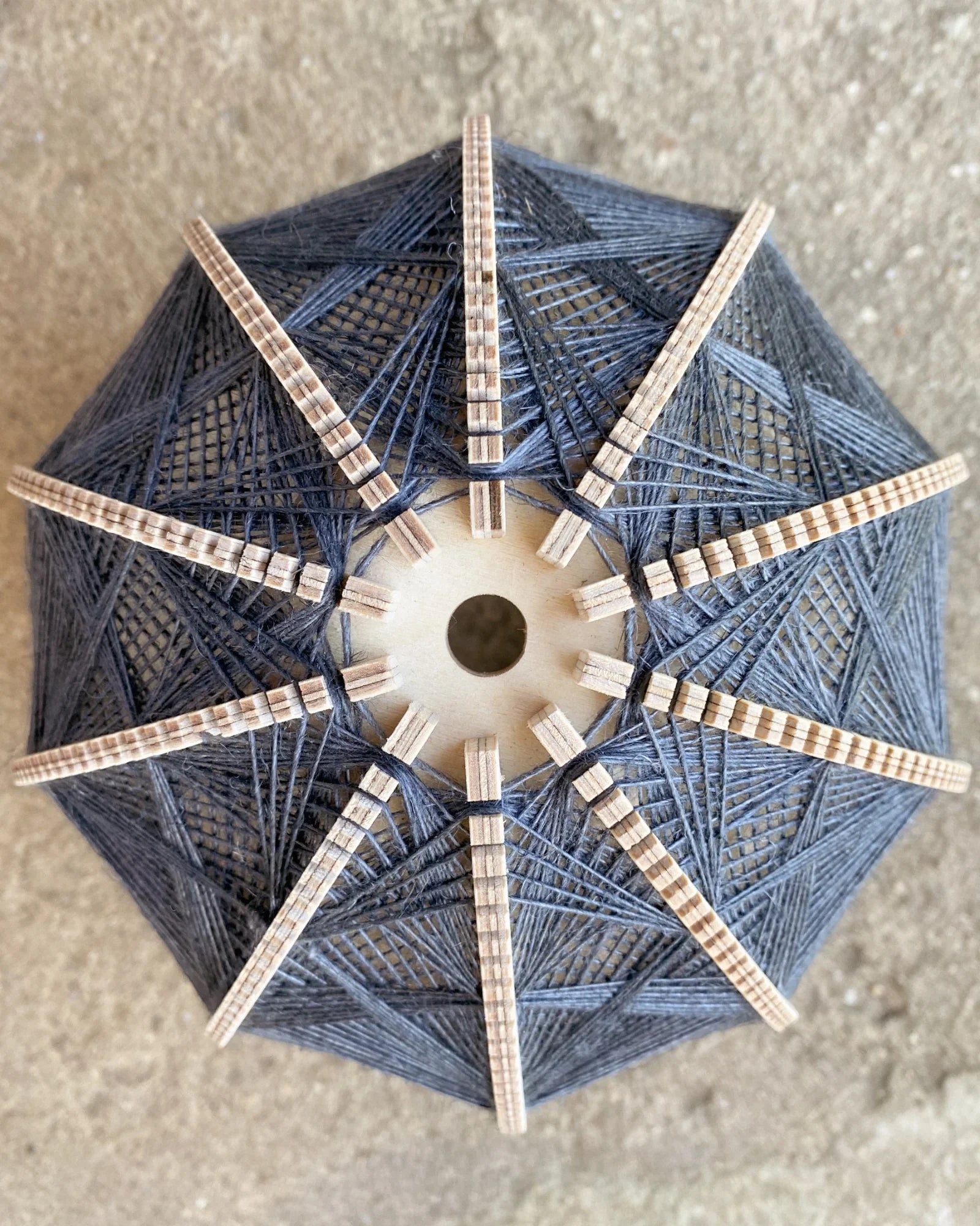 Detailaufnahme des Rahmens und Webmusters eines Lampenschirm aus Birkenholz und Leinengarn in Beige und Anthrazit