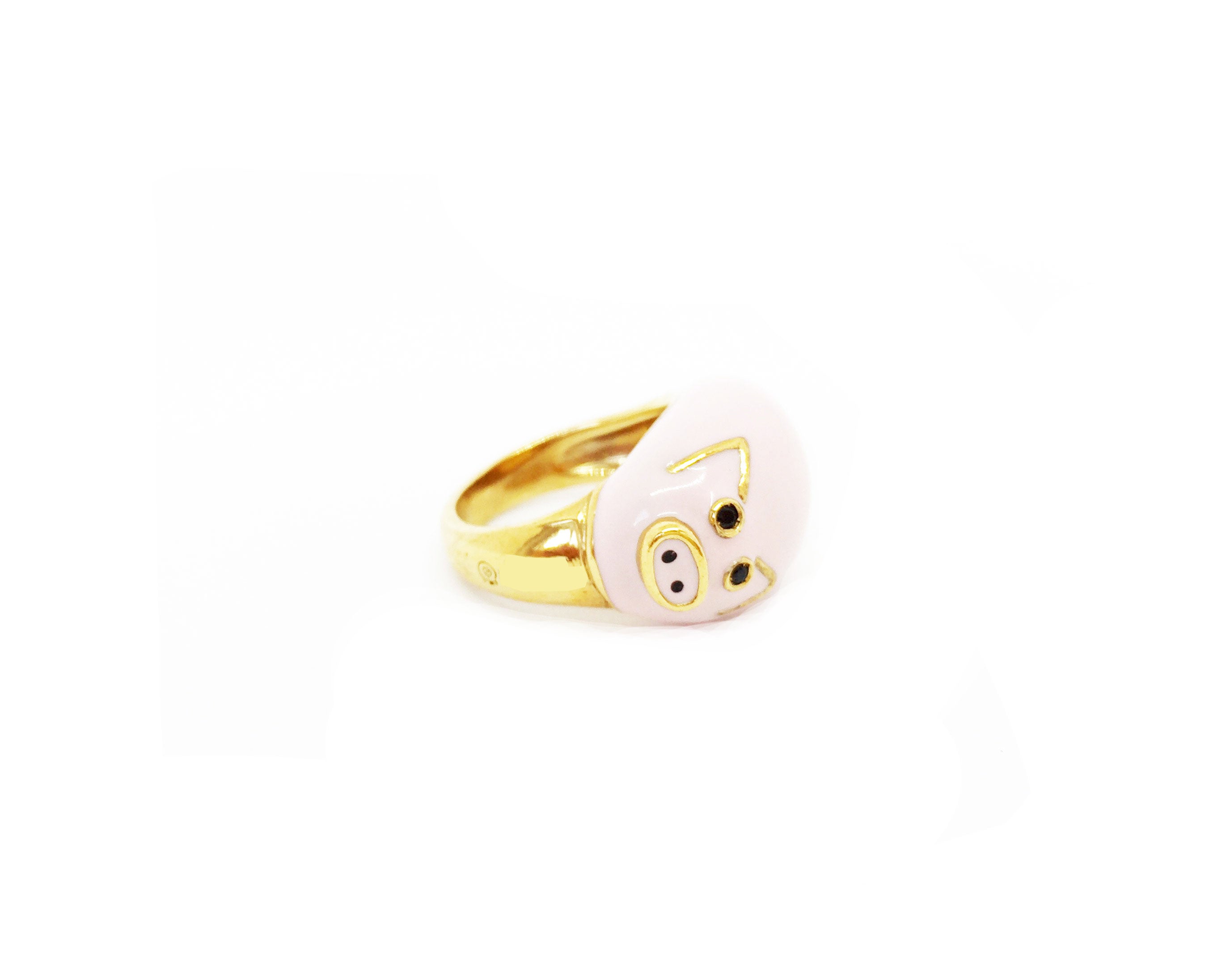 Seitliche Ansicht eines Ringfingers der italienischen Schmuckdesignerin Chiara Bello in Form eines rosa Schweinchens mit goldenen Ohren und schwarzen Steinchen als Augen.