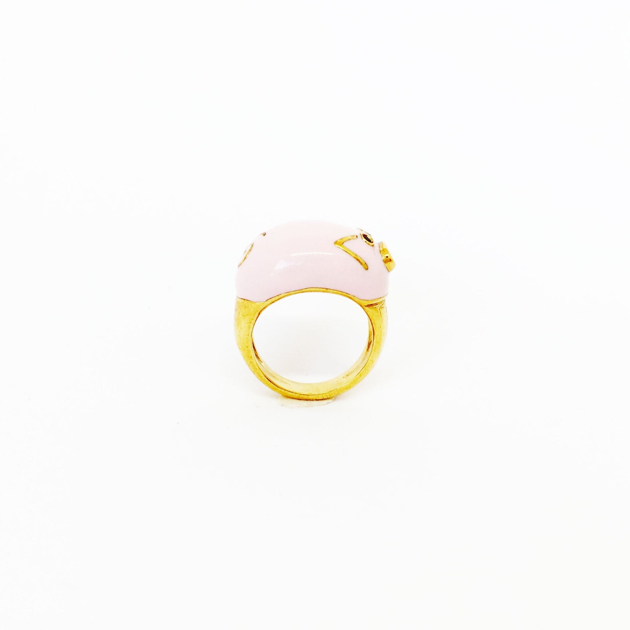 Frontanischt eines Fingerrings der italienischen Schmuckdesignerin Chiara Bello in Form eines rosa Schweinchens mit goldenen Ohren und schwarzen Steinchen als Augen.