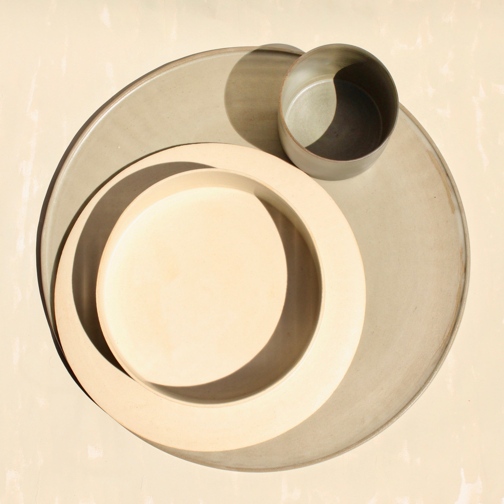 Ein modulares Set der handgefertigten Steingut-Kollektion ROSA MORADA der Genueser Künstlerin Martina Geroni, bestehende aus einem grossemn Pizzateller/Platzset, einem Suppenteller/einer Schale und einem Becher.