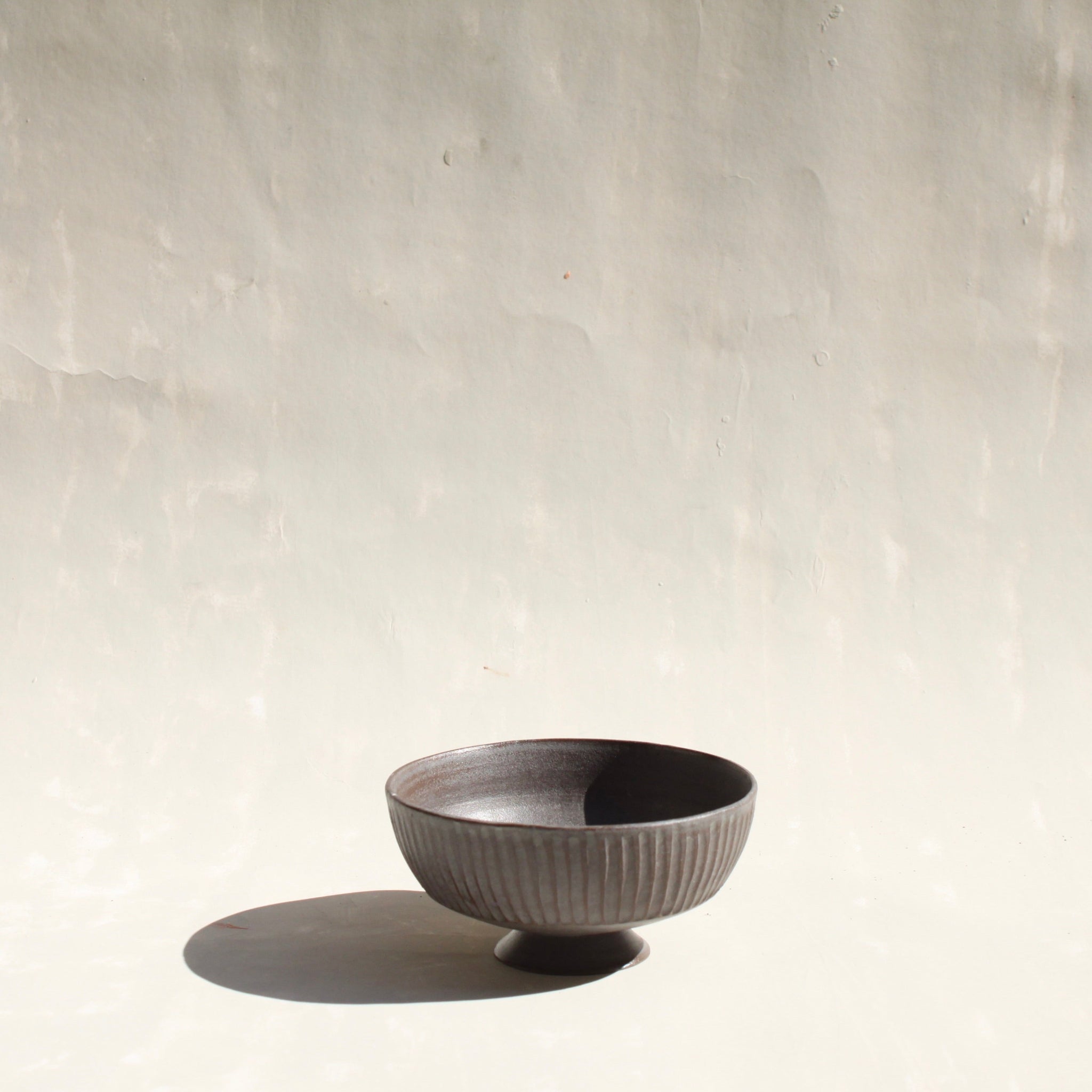 Becher aus dem Kaffeeset Airone von Martina Geroni, handgefertigtes Steingutobjekt mit gerippter Oberfläche, das zugleich als Fuß des Reihers innerhalb der modularen Geschirrskulptur in Form eines Reihers fungiert.