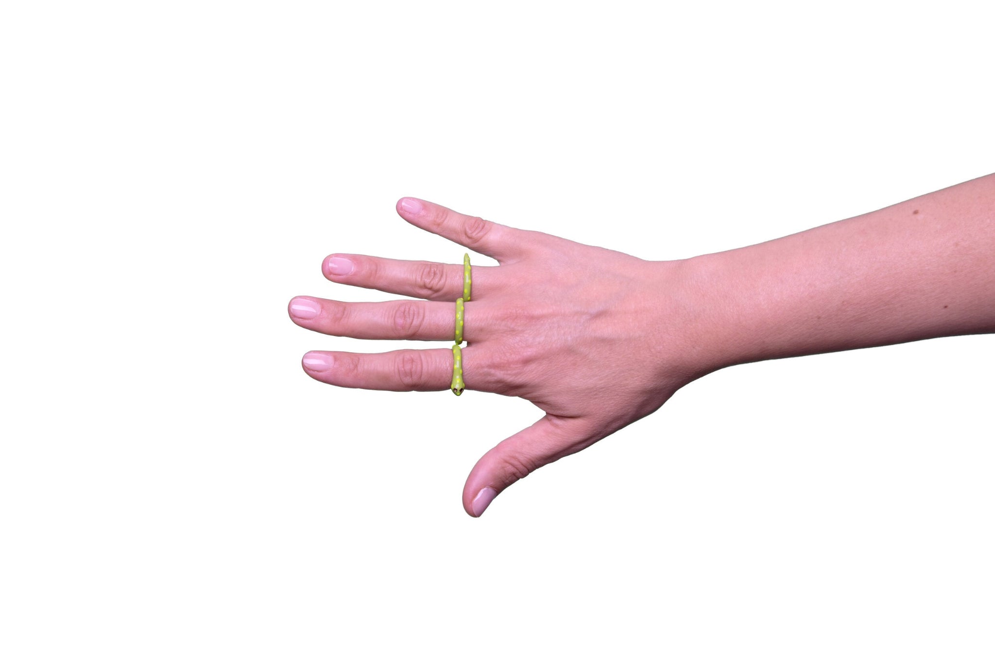 Eine Hand trägt am Ring-, Mittel- und Zeigefinger einen dreiteiligen Ring der italienischen Schmuckdesignerin Chiara Bello in Form einer grünen Schlange mit gelben Punkten, goldenen Konturen und schwarzen Steinchen als Augen.