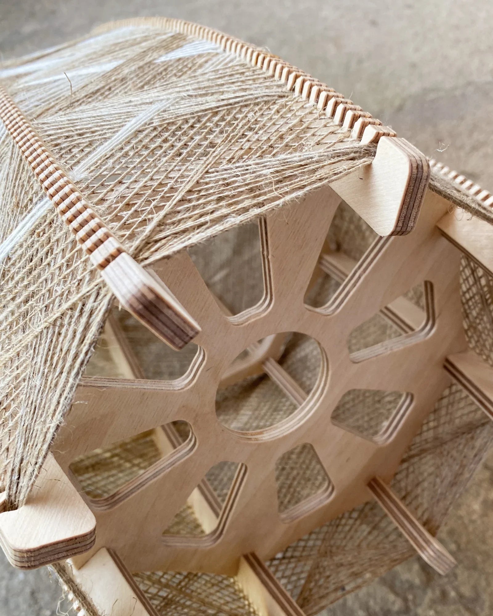 Detailaufnahme des Rahmens des gewebtem Lampenschirms aus Birkenholz und beigem Leinengarn