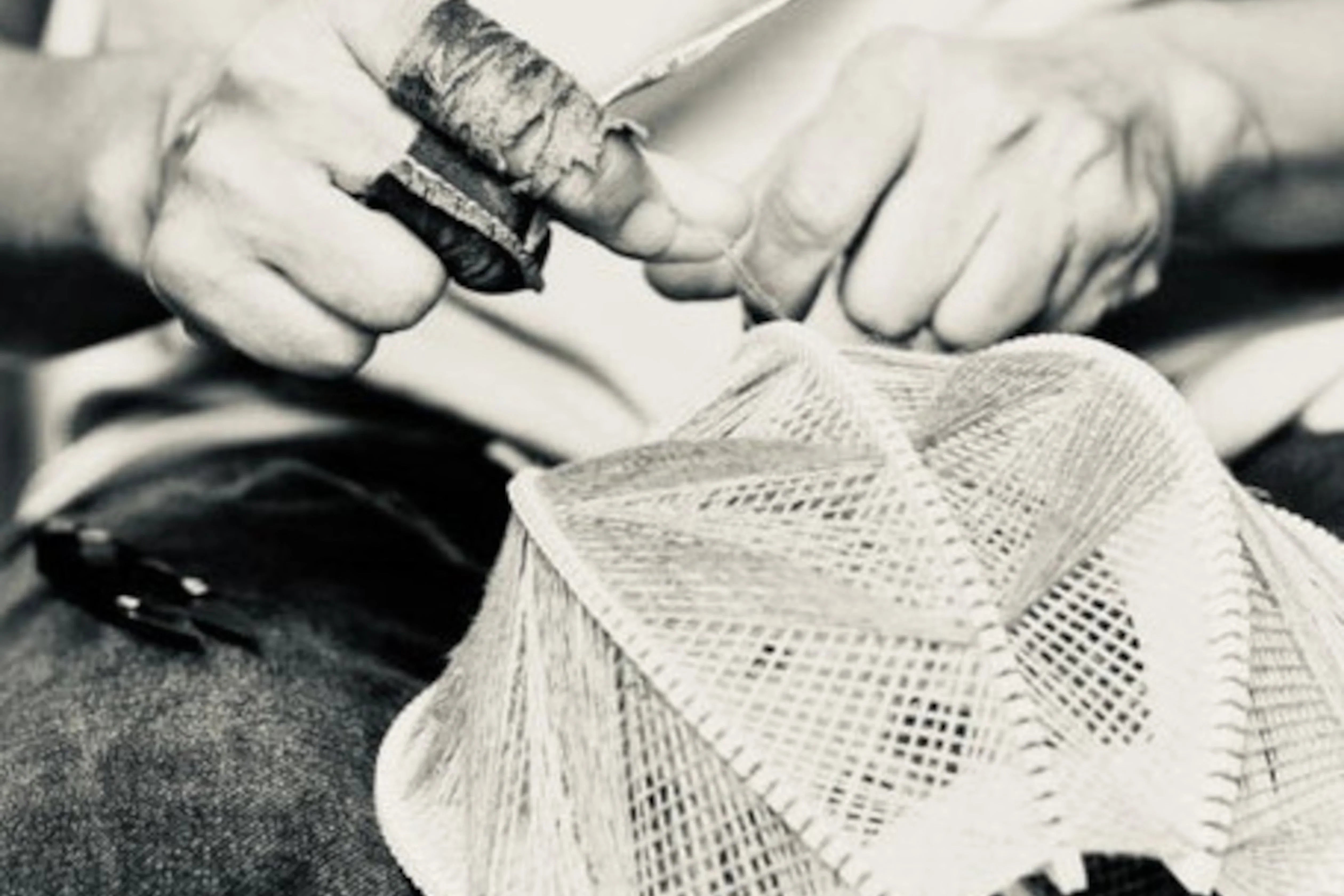 Nahaufnahme von zwei Händen, die einen Lampenschirm weben