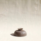 Becher aus dem Kaffeeset Airone von Martina Geroni, handgefertigtes Steingutobjekt mit gerippter Oberfläche, das zugleich als Fuß des Reihers innerhalb der modularen Geschirrskulptur in Form eines  Reihers fungiert.