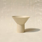 Der Becher TABLINO aus Keramik kann sowohl als kegelförmges Schälchen mit  zylindrischem Sockel für Tee genutzt werden, oder gewendet als Espressobecher mit kegelförmigen Fuss. 
