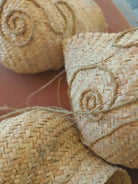 Detailaufnahme aus dem Fertigungsprozess der Wandskulptur CARRIERS von Ysaline Ophoff: handgeflochtene Module aus getrockneten Palmwedeln und Esparto-Gras, mit sichtbaren Flechtstrukturen, Spiralnähten und locker geführten Pflanzenfasern während der handwerklichen Verarbeitung.