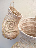 Detailansicht eines der drei Module der handgeflochtenen Wandskulptur CARRIERS von Ysaline Ophoff: organisch geformtes Hängeobjekt aus Palmwedeln und Esparto-Gras mit strukturierter Oberfläche und integrierter Aufhängung aus Naturfasern.