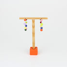 Handgefertigte Statement-Creolen aus Silber mit jeweils acht bunten Polymerton-Kugeln, präsentiert auf einem Holzständer vor hellem Hintergrund.