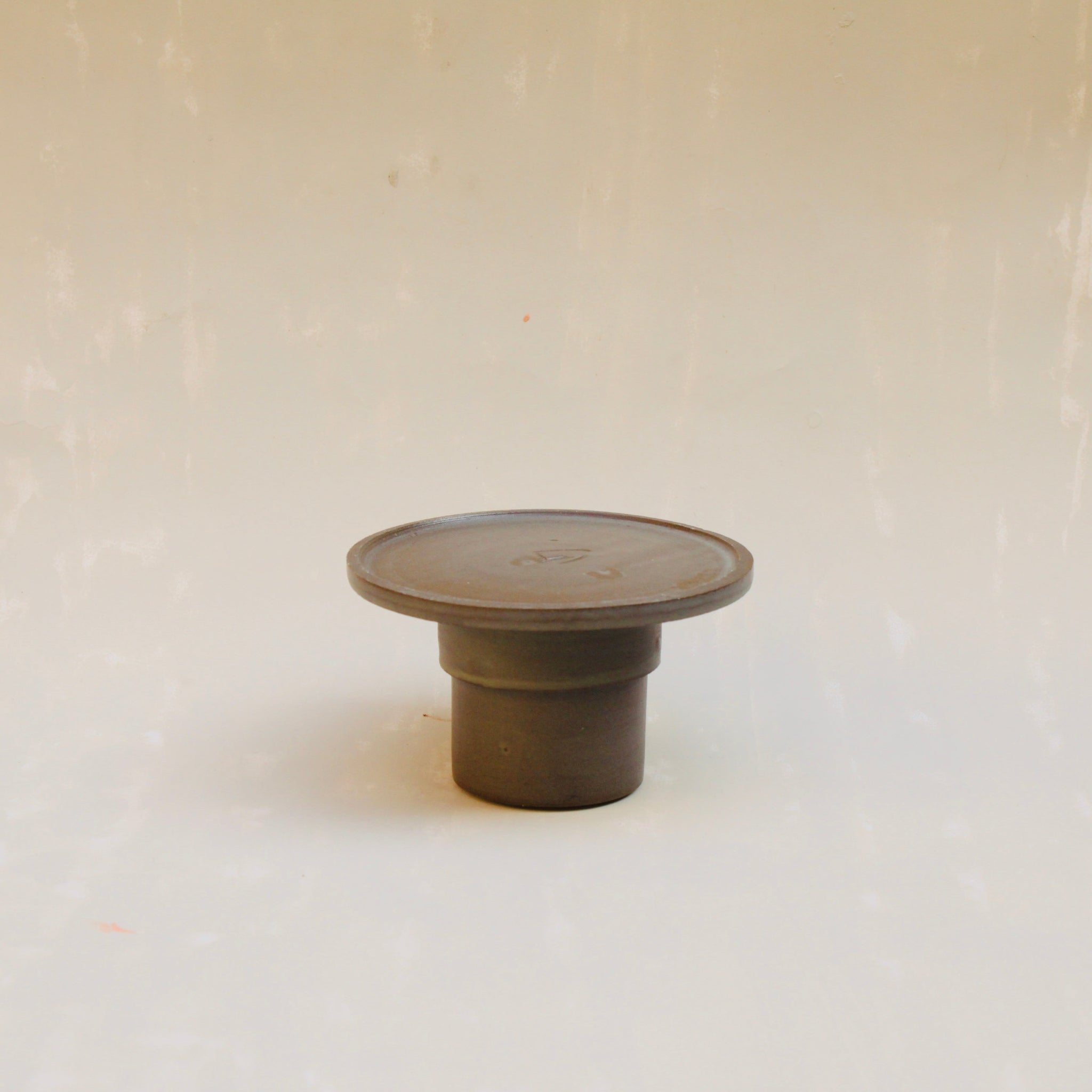 Modularer Espressobecher mit Schälchen aus der Kollektion ROSA MORADA von Martina Geroni in der Tonfarbe Buccia di Zenzero, handgefertigt aus Steingut, als kleine Geschirrskulptur arrangiert.