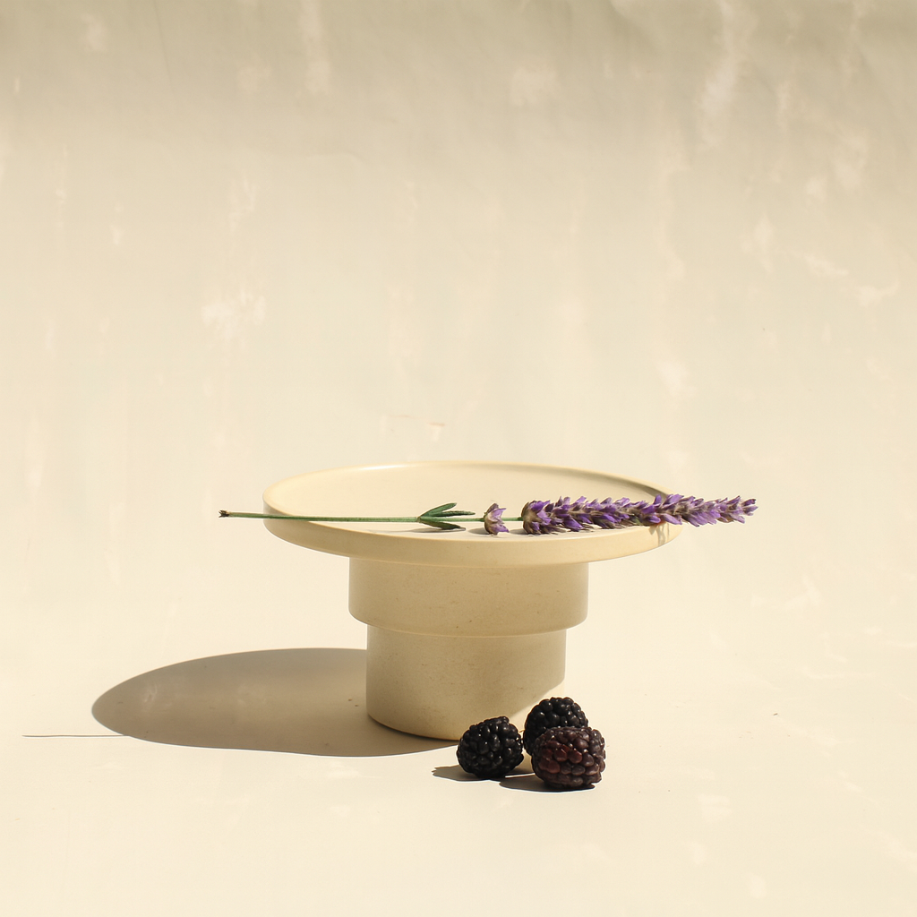 Modularer Espressobecher mit Schälchen aus der Kollektion ROSA MORADA von Martina Geroni in der Tonfarbe Fiore di Cotone, handgefertigt aus Steingut, als kleine erhöhte Platte arrangiert, mit Lavendelzweig und Brombeeren.