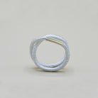 Ein silberner Fingerring, der aussieht wie ein Haargummi, den man sich um den Finger wickelt - gefertigt von der Straßburger Goldschmiedin Annie Sibert.