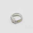 Ein silberner Fingerring, der aussieht wie ein verknotetes, dünes Haargummi - gefertigt von der französischen Goldschmiedin Annie Sibert.