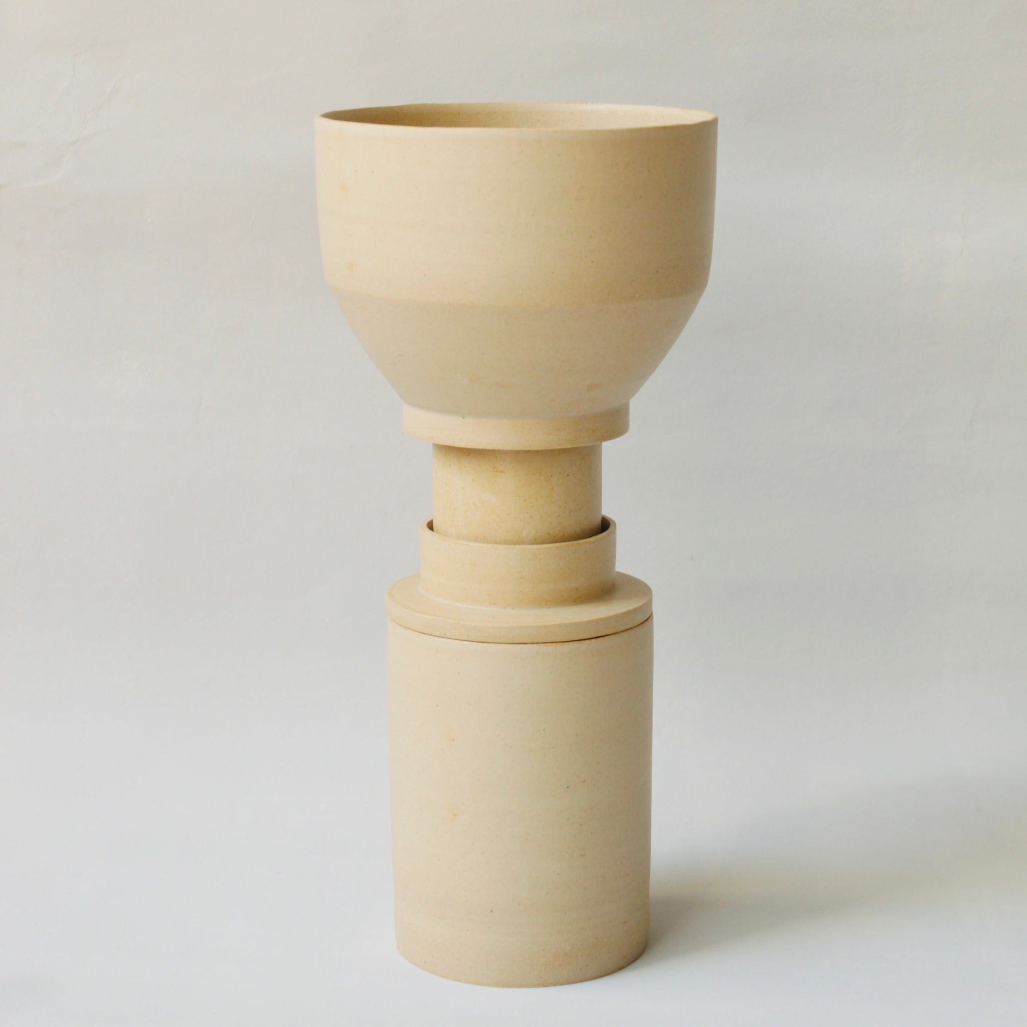 Gestapelte Geschirrskulptur Caramella aus der Kollektion ROSA MORADA von Martina Geroni in der Tonfarbe Miele, bestehend aus Espressotasse mit Untertasse, Becher und Schale aus handgefertigtem Steingut.