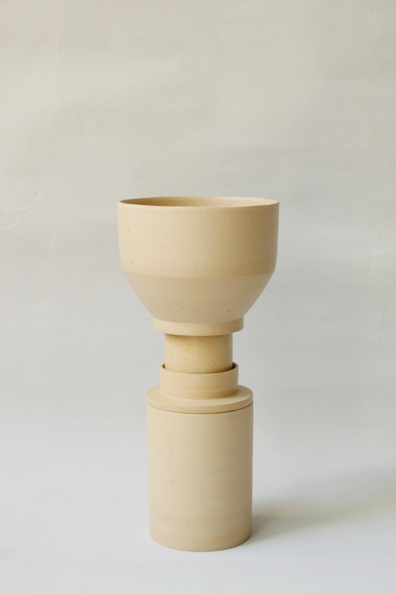 Gestapelte Geschirrskulptur Caramella aus der Kollektion ROSA MORADA von Martina Geroni in der Tonfarbe Miele, bestehend aus Espressotasse mit Untertasse, Becher und Schale aus handgefertigtem Steingut.