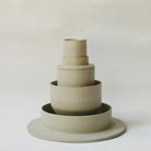 Gestapelte Geschirrskulptur Fefé aus der Kollektion ROSA MORADA von Martina Geroni in der Tonfarbe Salvia, bestehend aus Espressotasse mit Untertasse, Becher, Schale und tiefem Teller aus handgefertigtem Steingut.