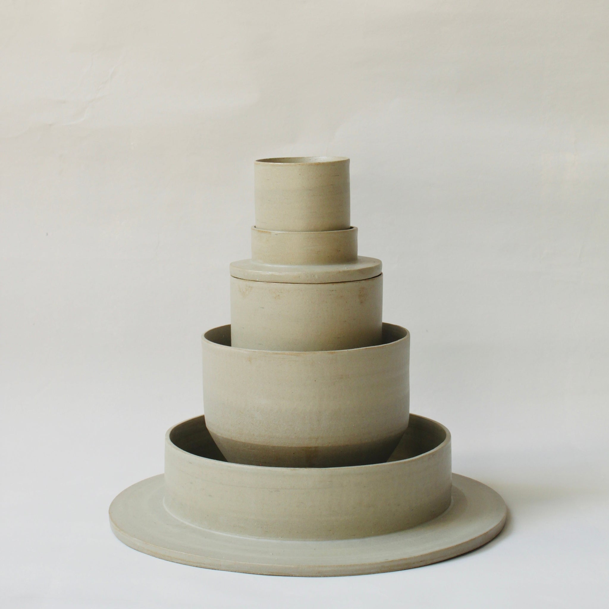 Gestapelte Geschirrskulptur Fefé aus der Kollektion ROSA MORADA von Martina Geroni in der Tonfarbe Salvia, bestehend aus Espressotasse mit Untertasse, Becher, Schale und tiefem Teller aus handgefertigtem Steingut.