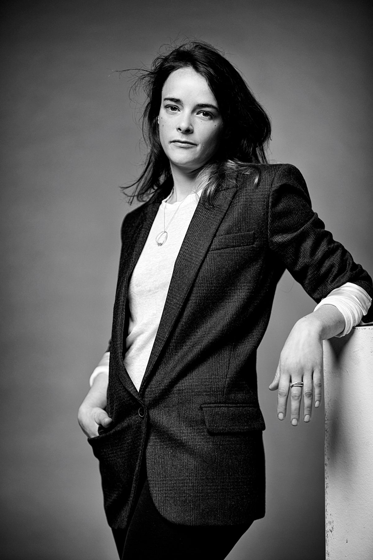 Schwarz-weiss Porträt der Schmuckdesignerin und Gold- und Silberschmiedin Annie Sibert in einem karierten Jacket. 