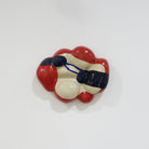 Keramische Wandskulptur mit organisch gewölbter Form; cremefarbener Grundton mit leuchtend roten Flächen sowie dunkelblauen, gestischen Linien- und Flächenakzenten auf der Oberfläche.