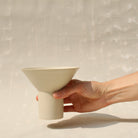Der Becher TABLINO aus Keramik kann sowohl als kegelförmges Schälchen mit  zylindrischem Sockel für Tee genutzt werden, oder gewendet als Espressobecher mit kegelförmigen Fuss. 