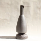 Eine Keramikkaraffe in Form eines stilisierten Reihers, mit einem abnehmbaren Schälchen als Fuss